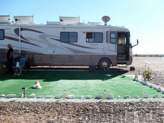 Personal oasis
White rocks and grass mats popular. Satellite dishes and solar panels too. For water he uses several large blue barrels.
