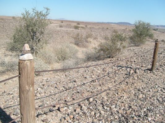Tourists add their own marks by piling rocks on fence posts
