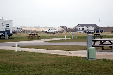 Camp Hatteras on Cape Hatteras in Waves, NC
The Atlantic Ocean is just beyond the dunes at the back. This camprgound spans fully across the island and offers both ocean camping on one side and calmer sound camping on the other side. It has both an inside and outside pool, hot tub, game room, TV lounge, camp store, laundry, full hookups, cableTV, wifi. It can be quite expensive but is a Coast to Coast member campground for cheaper camping.
