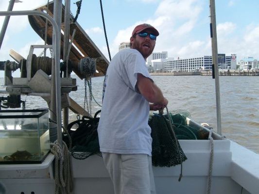 Learning shrimping in the Gulf
He's tying the bottom of the net closed. They will drag it behind to scoop up the shrimp. 
